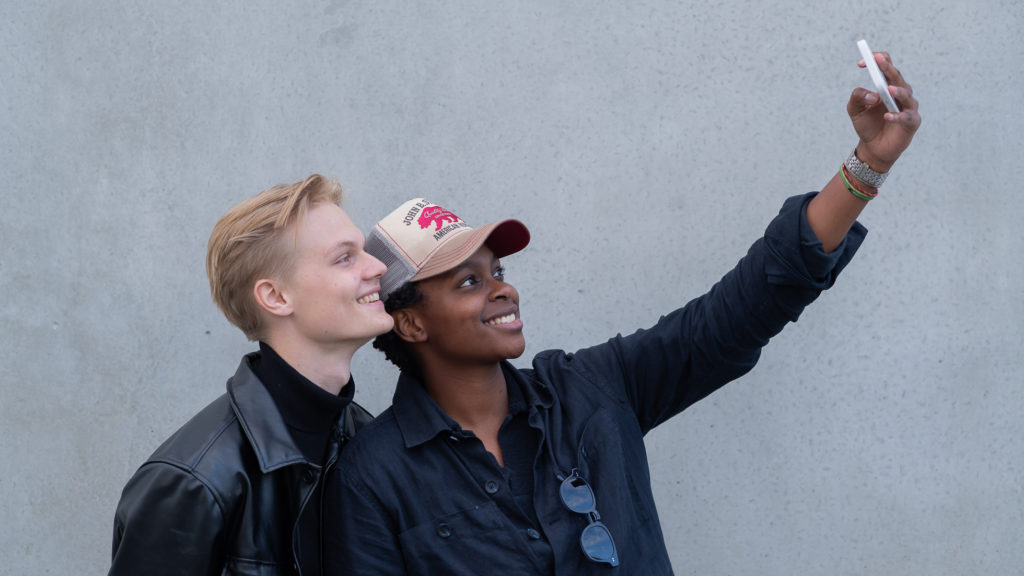Två killar som tar en selfie med mobilkamera.