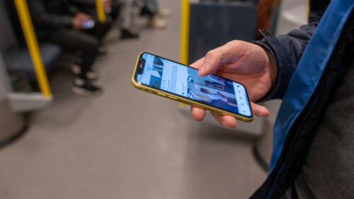 person kollar mobilen på tunnelbanan