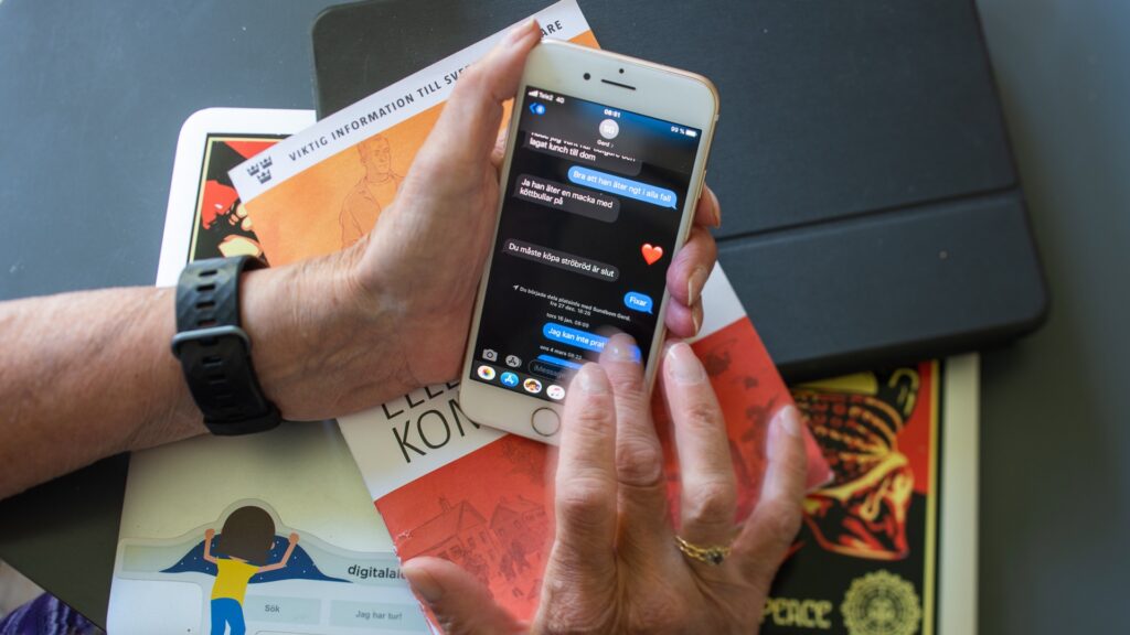 Händer som håller i en mobil, på mobilen syns en privat konversation.