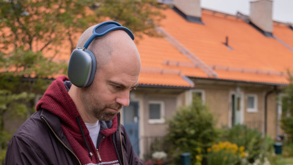 En man är utomhus, han lyssnar på ljudbok i hörlurar och ser koncentrerad ut.