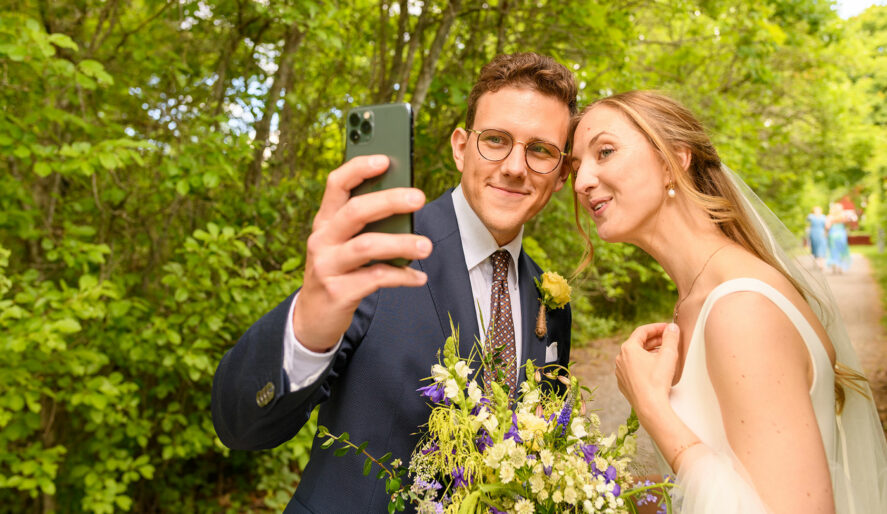 Ett brudpar tar en selfie med mobilkameran.