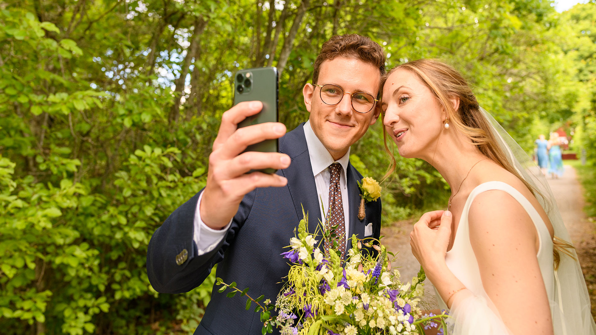 Ett brudpar tar en selfie med mobilkameran.