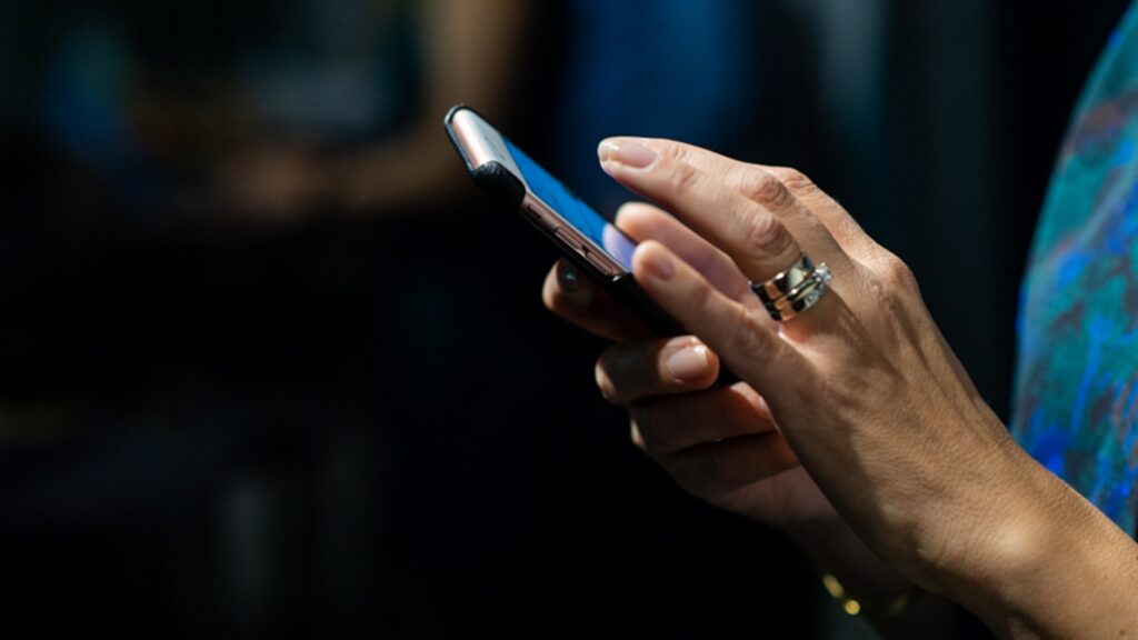 En närbild på en person som håller i en mobiltelefon.