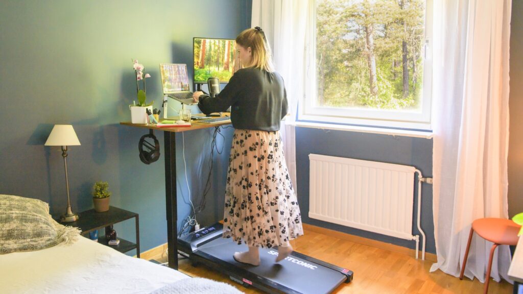 En kvinna som går på ett gåband samtidigt som hon jobbar.