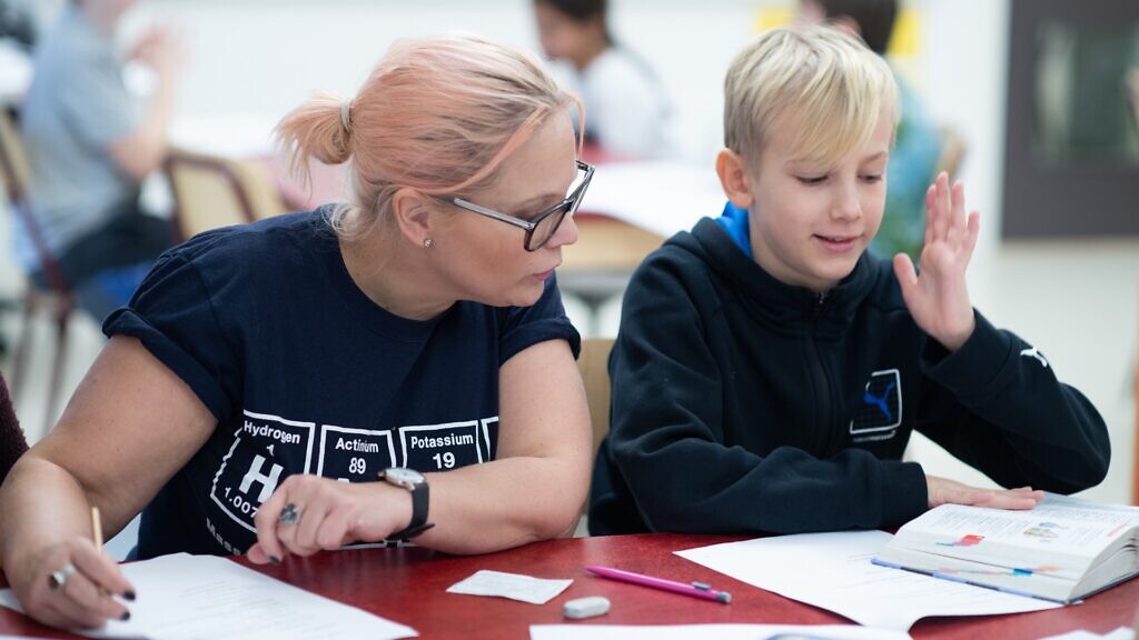 En kvinna och en pojke sitter vid ett bord.
