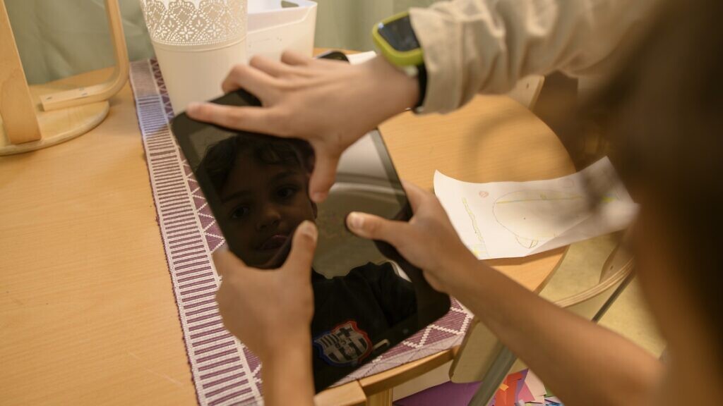 Två barn håller i en ipad tillsammans.