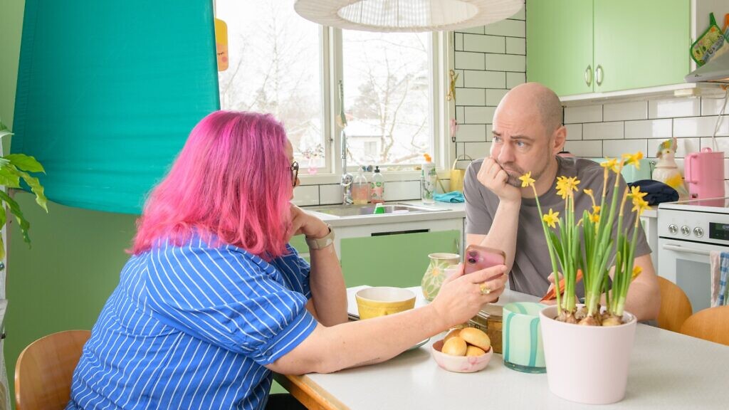 En man och en kvinna sitter vid ett köksbord.