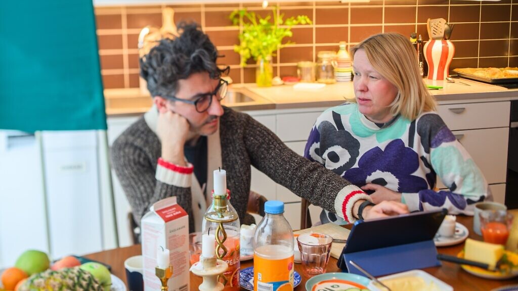 En man och en kvinna sitter vid ett köksbord och diskuterar politik.