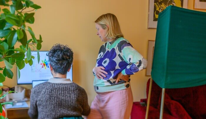 En man och en kvinna står framför en dator.