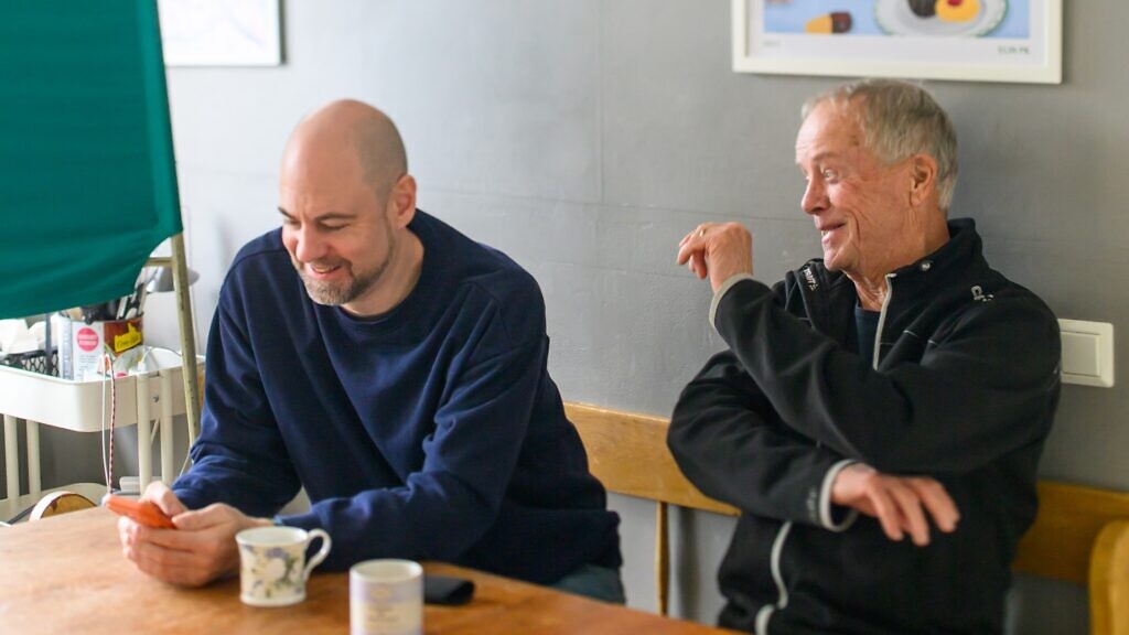 Några män sitter vid ett träbord.