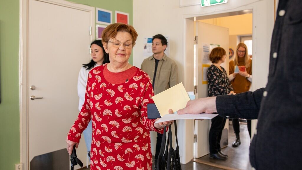 En kvinna som lämnar in en valsedel.