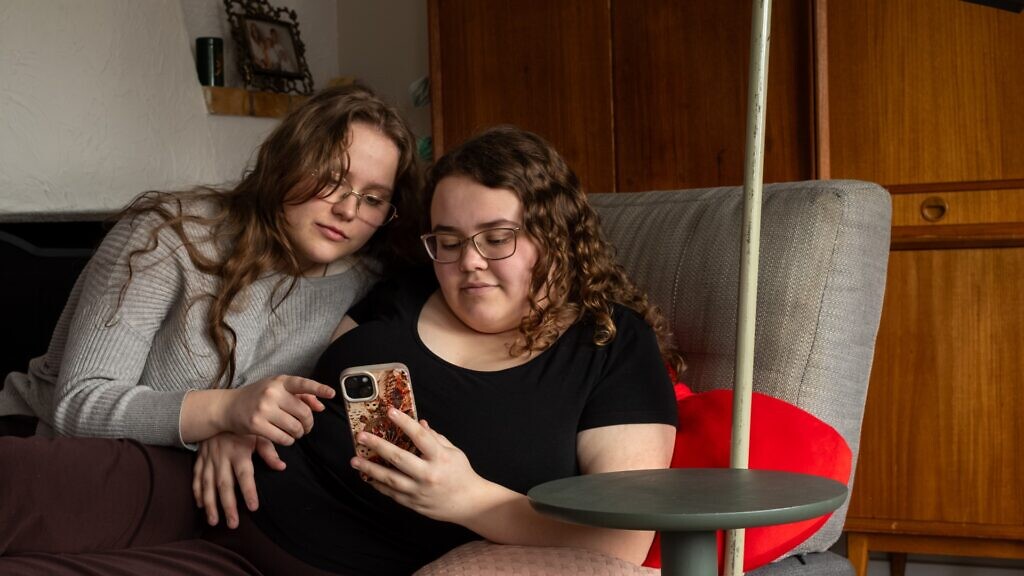 Några kvinnor som sitter bredvid varandra i en soffa.