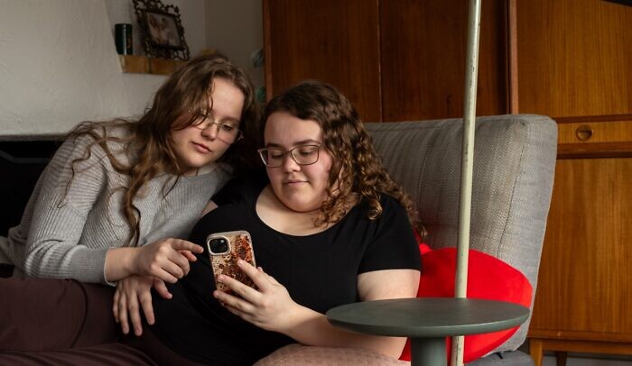 Några kvinnor som sitter bredvid varandra i en soffa.