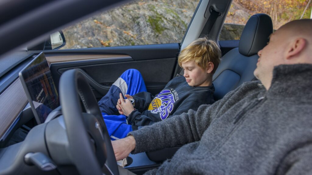En pappa och son sitter i en bil och pratar
