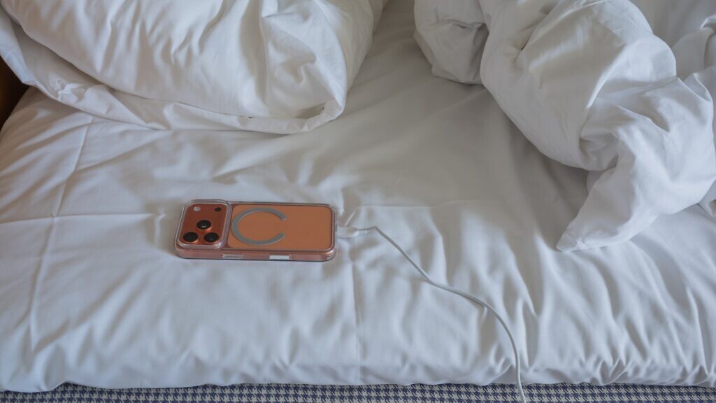 En mobiltelefon som ligger på sängen.