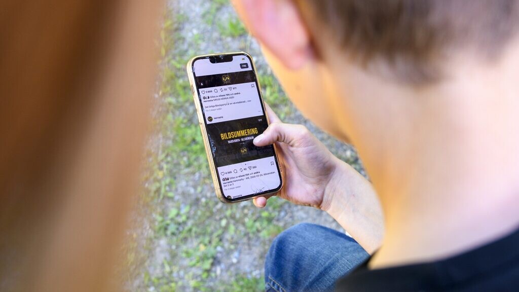 En person som håller en mobiltelefon i handen.